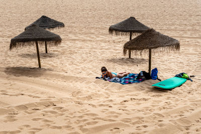 People relaxing on sand at beach