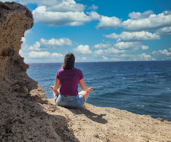 Rear view of woman looking at sea against sky