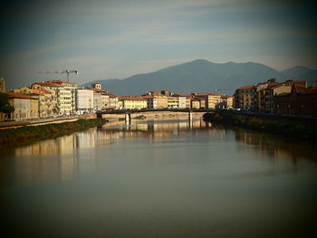 River by buildings in city against sky