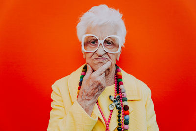 Portrait of woman wearing mask against red background