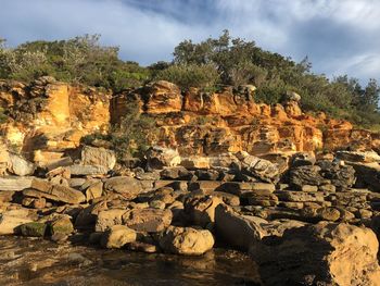 View of rock formation against cloudy sky