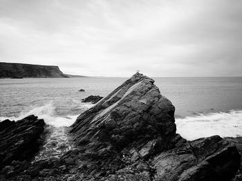 Rock formation on beach against sky