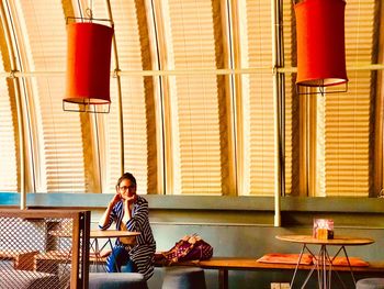 Portrait of young woman sitting at table in restaurant