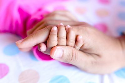 Close-up of baby hand on bed