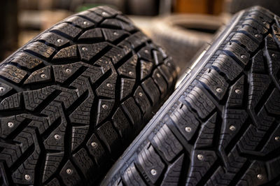 Closeup of snow tire with metal studs, which improve traction on icy surfaces, studded winter tyre