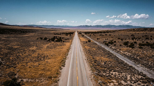 Road amidst field against sky