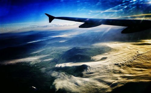 Cropped image of airplane wing over landscape