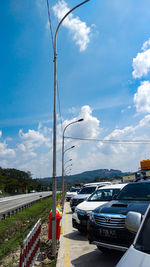 Cars on street against blue sky