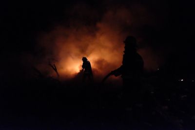 Silhouette of people against sky at night