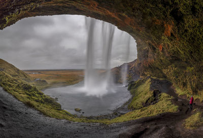 Scenic view of waterfall against sky