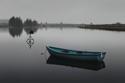 Boat moored in lake against clear sky