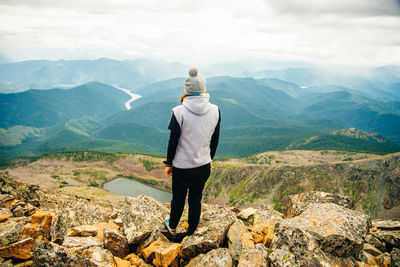 Rear view of man standing on rock