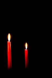 Close-up of lit candle against black background