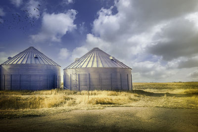 Built structure on field against sky