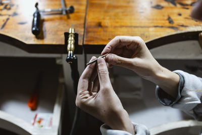 Cropped hands of man repairing car