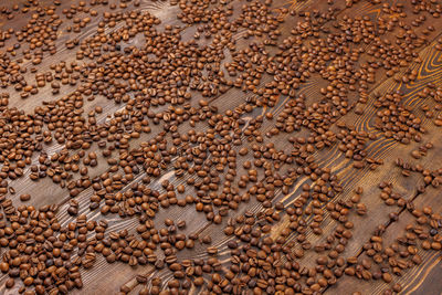 Roasted coffe beans spreaded over wooden board - full frame background