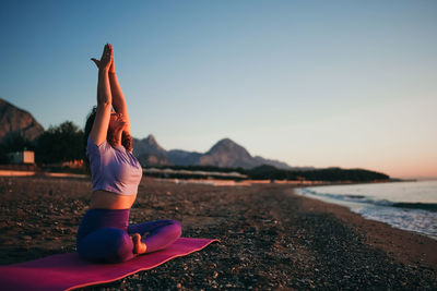 Low section of woman sitting on beach