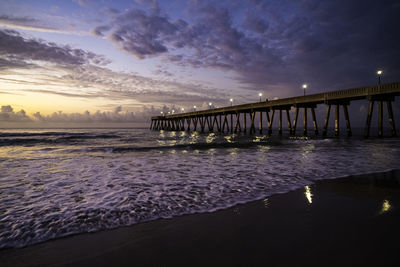 Pier over sea against sky during sunset