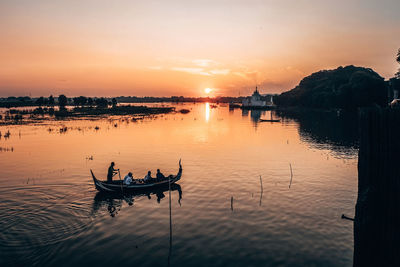 Fisherman fishing in river during sunset