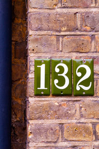 House number 132 on a brick wall in london