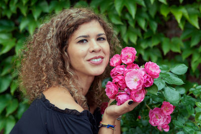 Portrait of smiling woman with pink flower