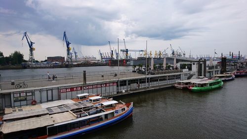 Boats moored at harbor against sky