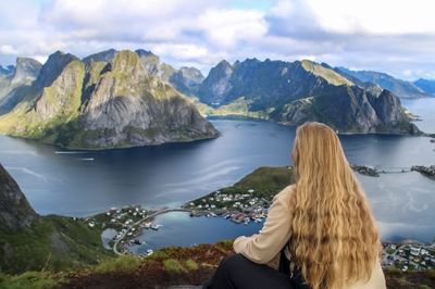 Rear view of woman looking at mountains against sky