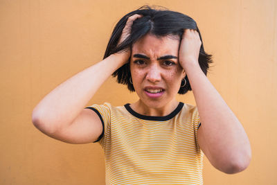 Portrait of woman standing against wall