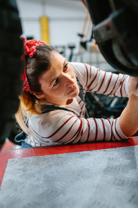 Mechanic woman checking motorcycle on factory