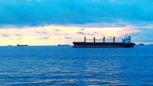 Ship sailing on sea against sky during sunset