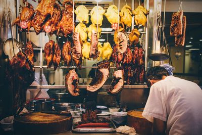 Rear view of vendor at meat shop