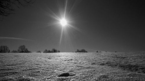 Scenic view of snowy field against sky during winter