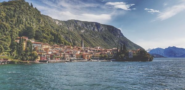 Scenic view of sea by townscape against sky