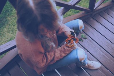 High angle view of baby sitting on wood