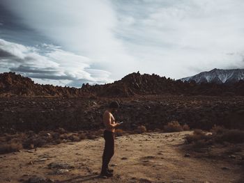 Full length of man standing on landscape against sky