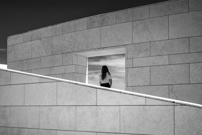 Woman walking on staircase against building