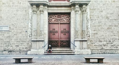 Man sitting at entrance of san martin de tours de fromista