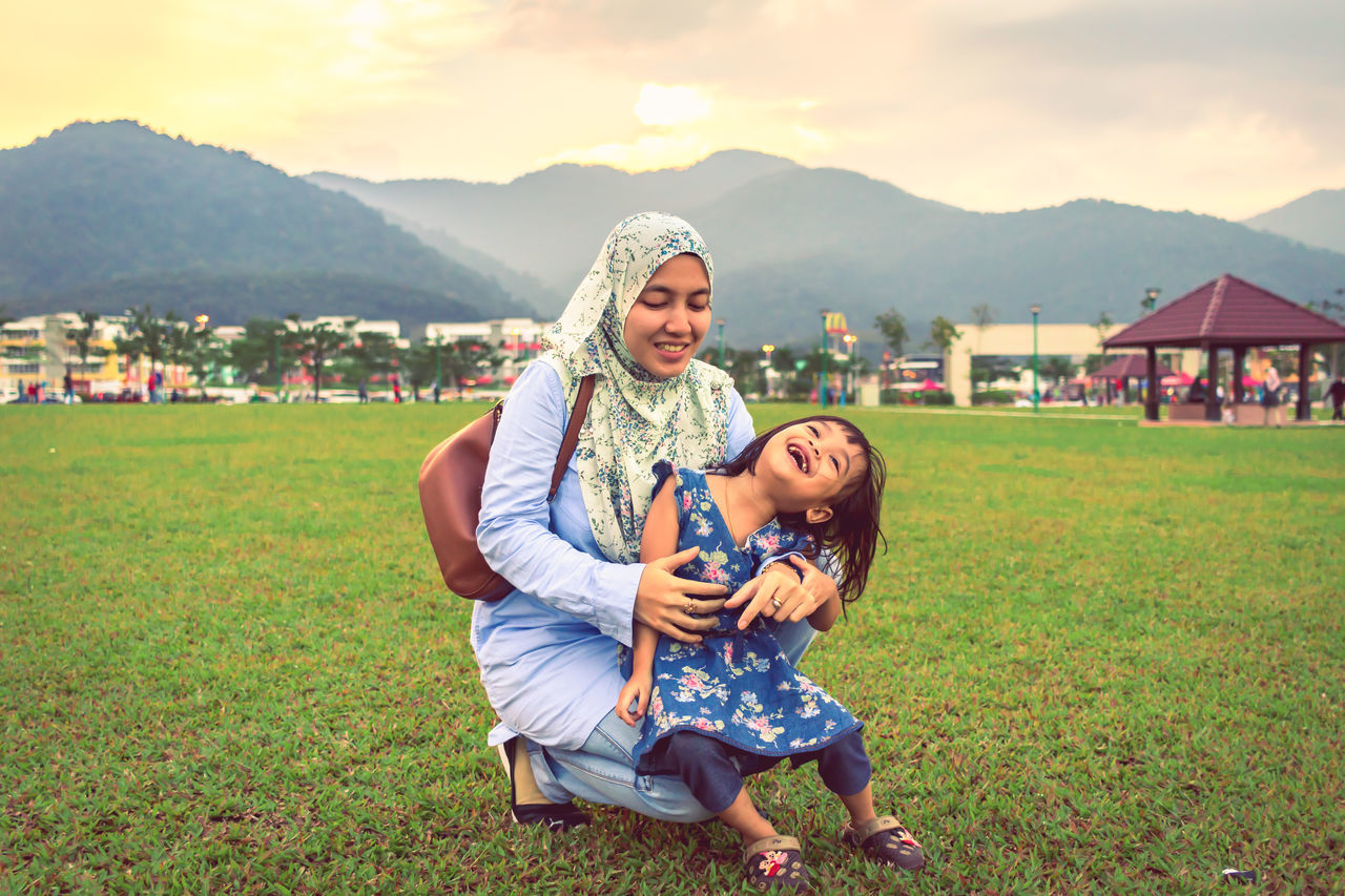 women, grass, females, mountain, emotion, real people, child, family, togetherness, happiness, bonding, leisure activity, smiling, adult, field, parent, family with one child, mother, casual clothing, daughter, positive emotion, innocence, mountain range