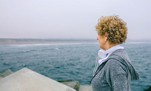 Woman looking at sea against sky