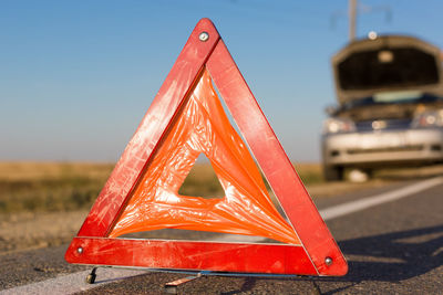 Close-up of red car on road against sky