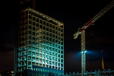 Low angle view of illuminated skyscraper against sky at night