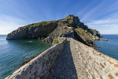 Rock formations by sea against sky