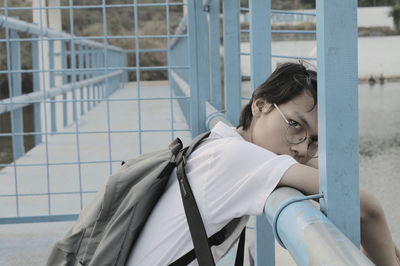 Portrait of woman standing by railing