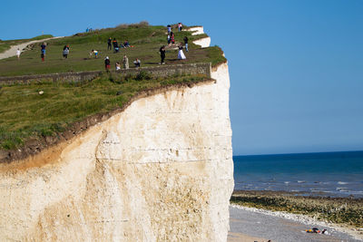 People at beach against clear sky