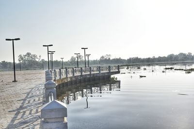 Wooden posts in lake against clear sky