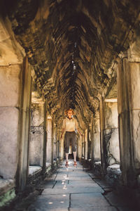 Woman levitating in corridor of historic building