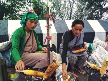 Happy friends sitting at market stall