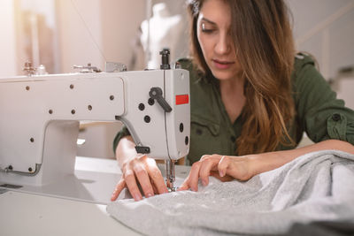 Woman sewing textile at boutique