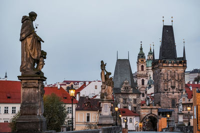 Statues in charles bridge and buildings in prague 