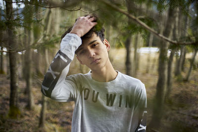 Portrait of young man standing at forest